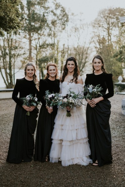 Bride and three bridesmaids in black dresses