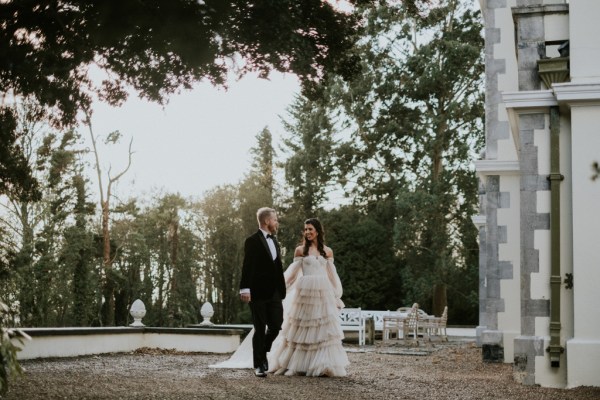 Bride and groom walk in forest setting hand in hand