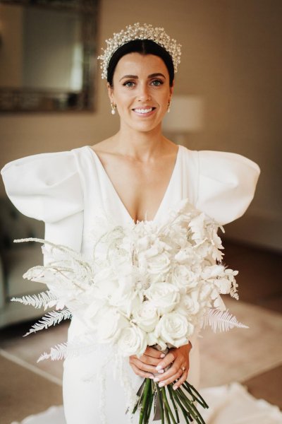 bride with white bridal bouquet white roses and white fern