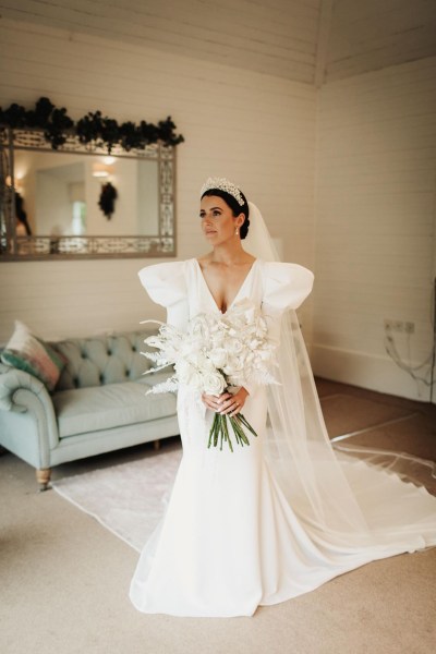 bride long sleeve dress puffy sleeves and headpiece headband white bridal bouquet white roses and white fern