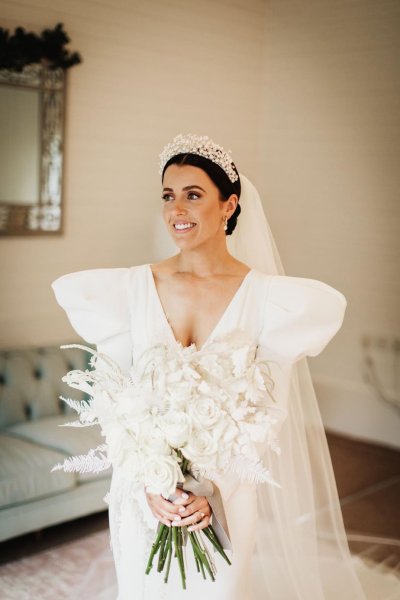 bride long sleeve dress puffy sleeves and headpiece headband white bridal bouquet white roses and white fern