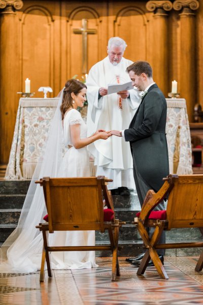 Bride groom at alter priest church kiss embrace hug