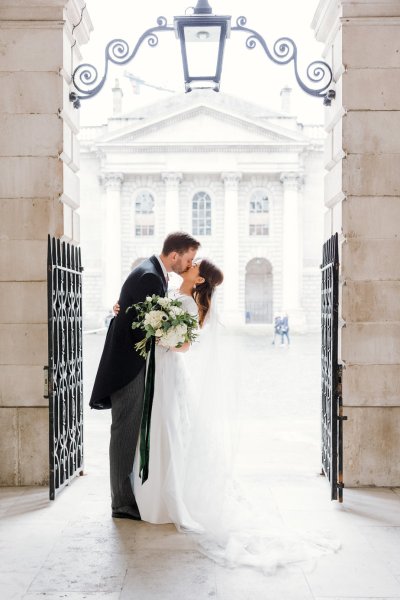 Bride and groom just wed outside of church kiss kissing