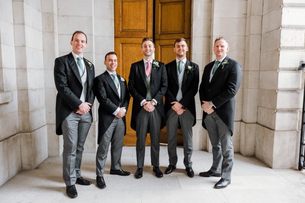 Groom and groomsmen pose outside church