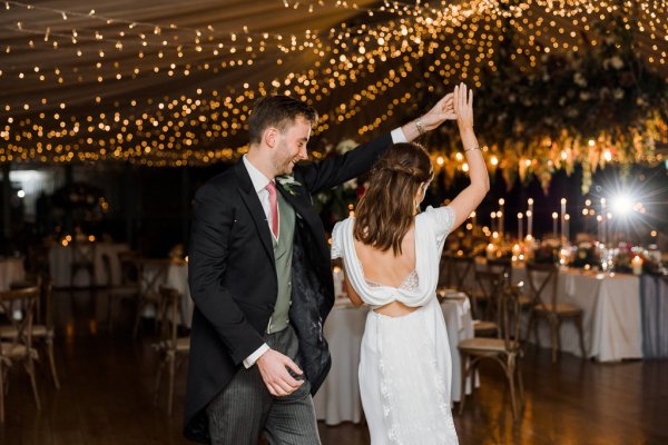 Bride groom first dance lights in background