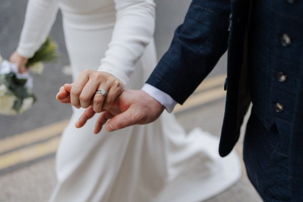 wedding rings holding hands