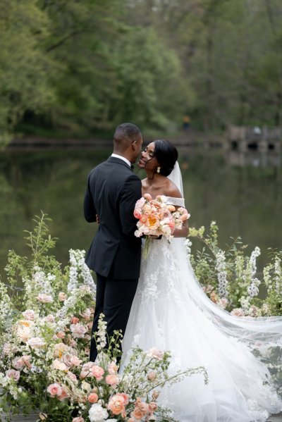 Bride and groom bouquet pink roses flowers elegant mountain scenic lake embrace