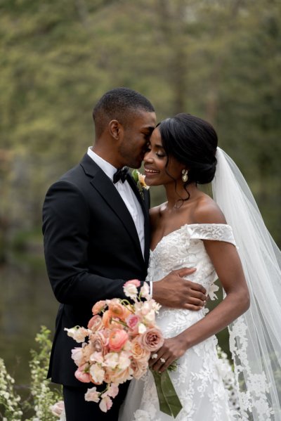 Bride and groom bouquet pink roses flowers elegant mountain scenic lake embrace