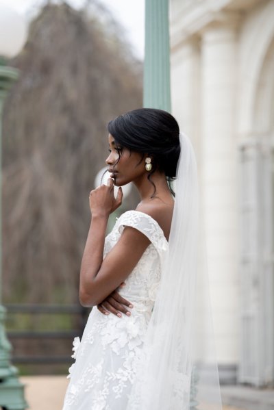 bride on her own exterior hotel pose earring detail