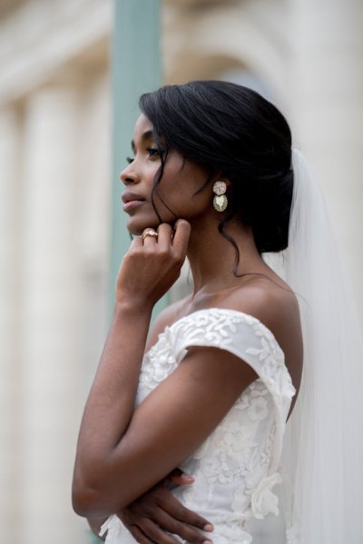 bride on her own exterior hotel pose earring detail