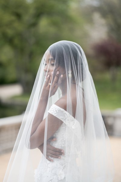 bride on her own exterior hotel pose earring detail veil