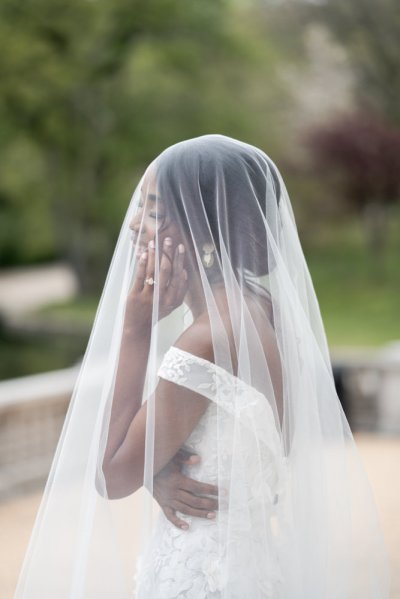 bride on her own exterior hotel pose earring detail veil