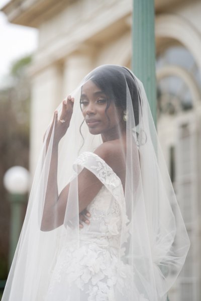 bride on her own exterior hotel pose earring detail veil