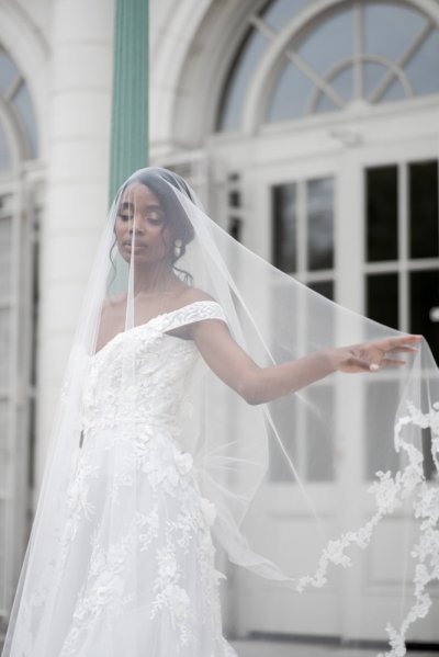 bride on her own exterior hotel pose earring detail veil