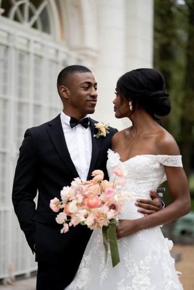 Bride and groom embrace earring detail exterior hotel flowers bouquet