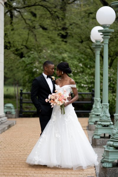 Bride and groom embrace earring detail exterior hotel flowers bouquet