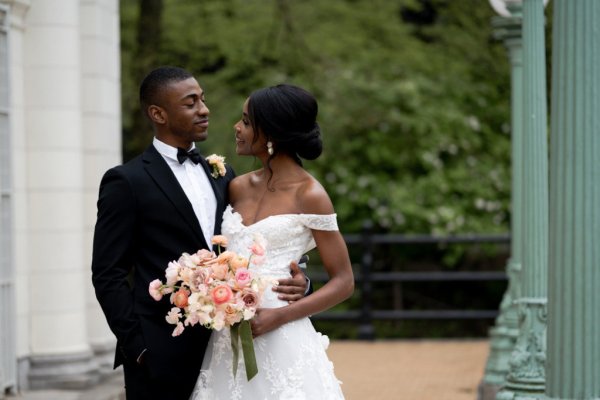 Bride and groom embrace earring detail exterior hotel flowers bouquet