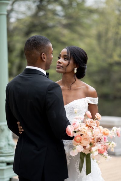 Bride and groom embrace earring detail exterior hotel flowers bouquet