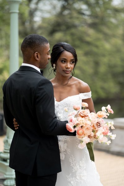 Bride and groom embrace earring detail exterior hotel flowers bouquet