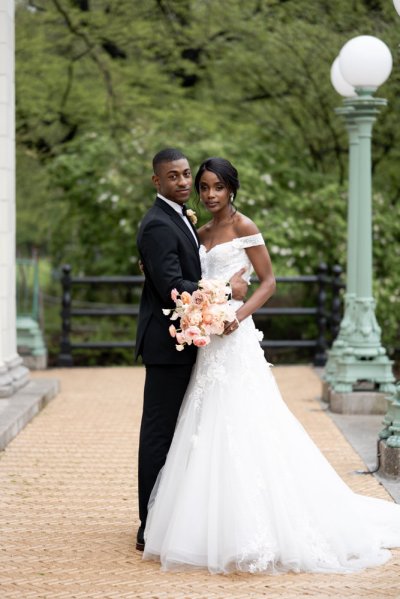 Bride and groom embrace earring detail exterior hotel flowers bouquet pink roses