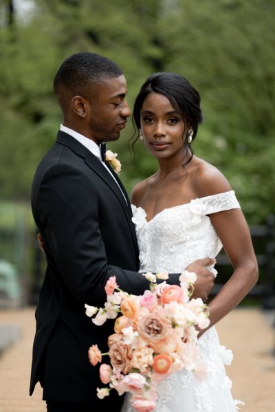 Bride and groom embrace earring detail exterior hotel flowers bouquet