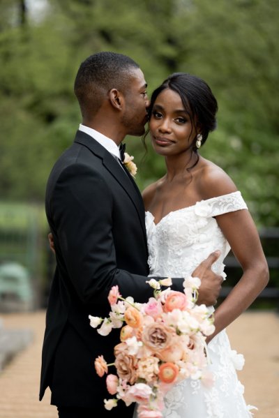 Bride and groom embrace earring detail exterior hotel flowers bouquet