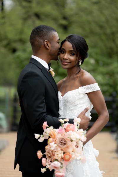 Bride and groom embrace earring detail exterior hotel flowers bouquet