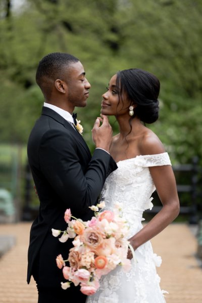 Bride and groom embrace earring detail exterior hotel flowers bouquet