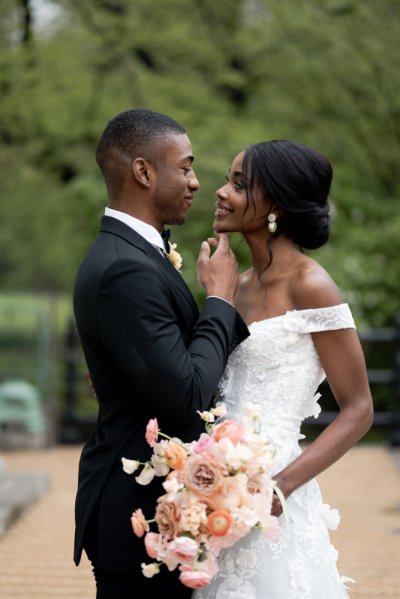 Bride and groom embrace earring detail exterior hotel flowers bouquet