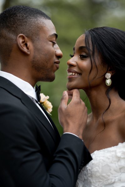 Bride and groom kiss flowers embrace