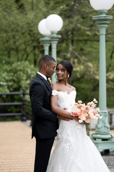 bride and groom holding flowers bouquet exterior