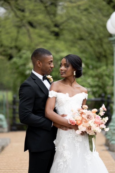 bride and groom holding flowers bouquet exterior