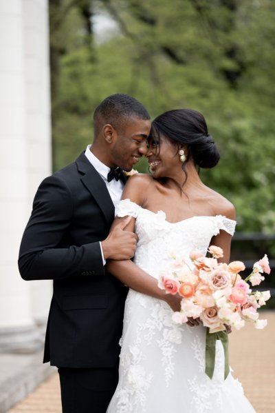 bride and groom holding flowers bouquet exterior