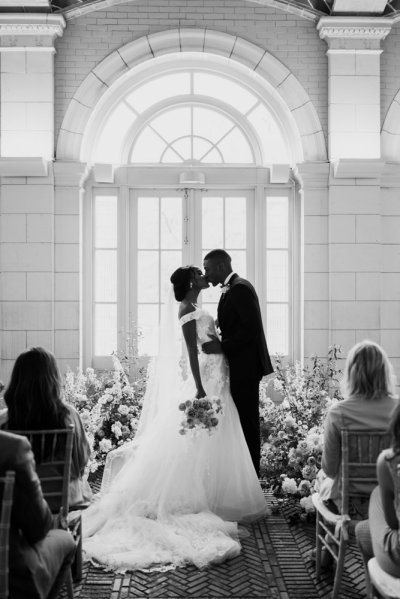 Black and white Bride and groom at the alter pink roses bouquet flowers