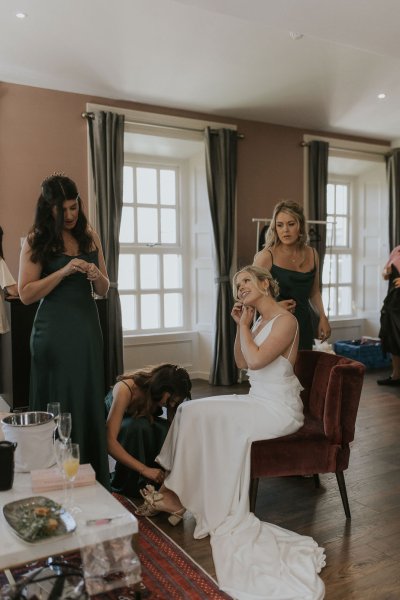 Bride putting on earrings bridemaids