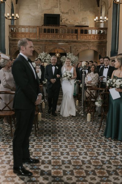 Father walking daughter bride down the aisle groom guests