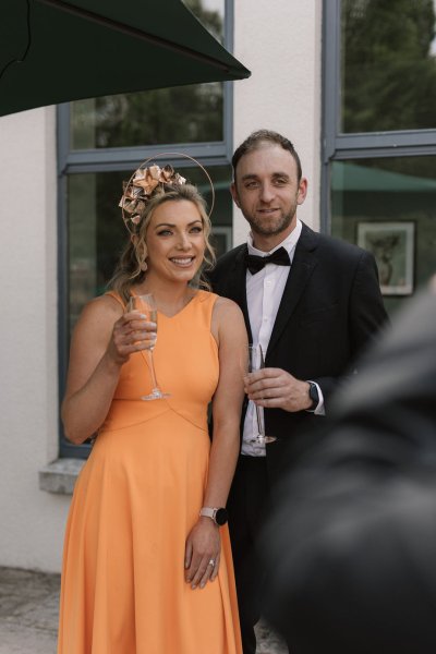 Guests orange dress smiling cheers headpiece