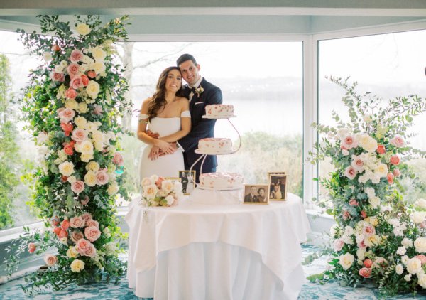 bride and groom posing with cake