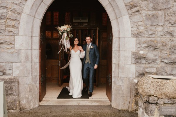 Bride and groom exiting church flowers