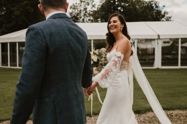 Bride and groom walking hand in hand holding hands