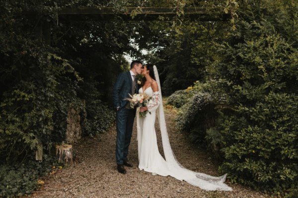 Bride and groom look at each other kiss