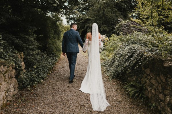 Bride and groom walking hand in hand holding hands