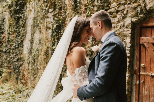 Bride groom embrace earrings veil flowers field grass