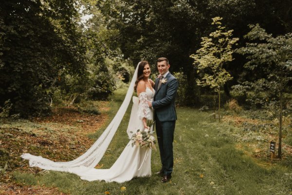 Bride groom embrace earrings veil flowers field grass