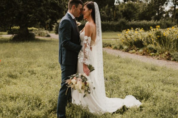 Bride groom embrace earrings veil flowers