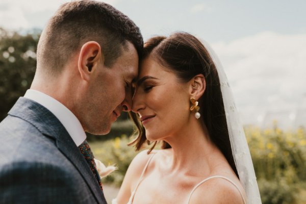 Bride groom embrace earrings veil