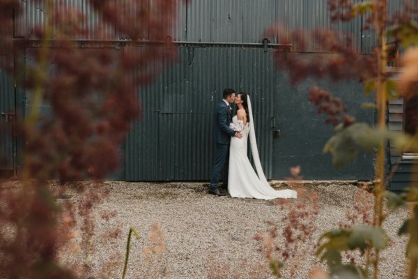 Bride and groom kiss exterior