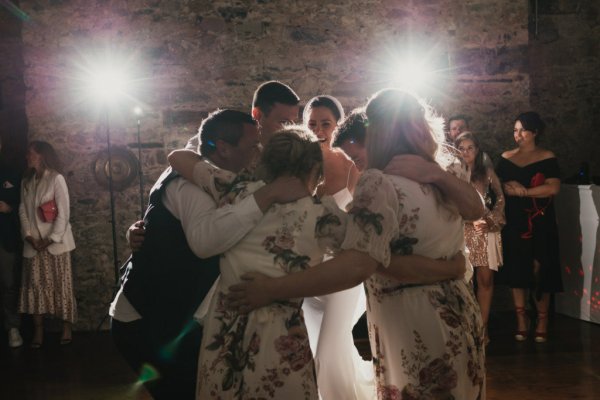 Guests smiling bride groomsmen hugging