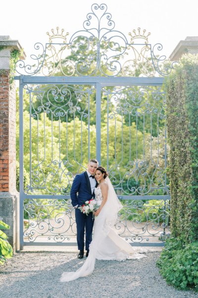 Bride groom exterior veil garden holding hands