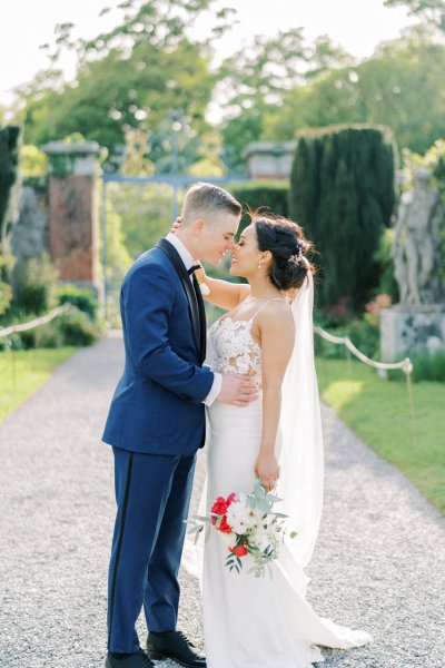 Bride groom exterior veil garden holding hands flowers bouquet